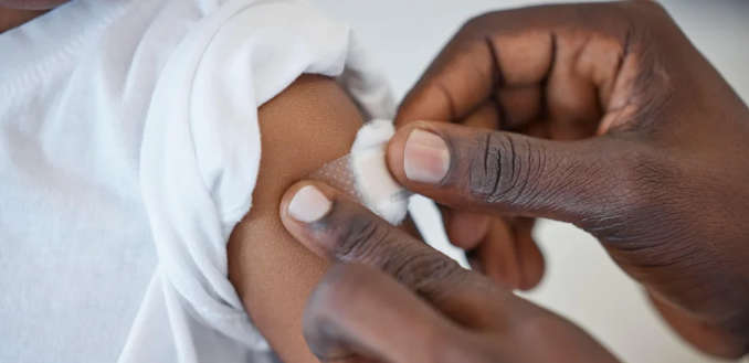 A picture of a person applying a bandage to a patient's arm