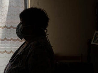 Covid patient wearing mask in a dark room