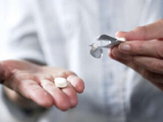 Person holding pill in hand