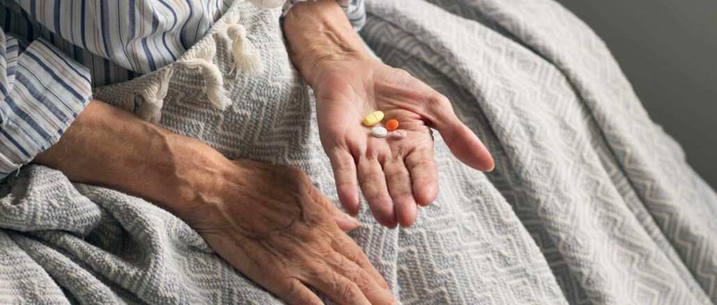 Picture of an old woman holding medication